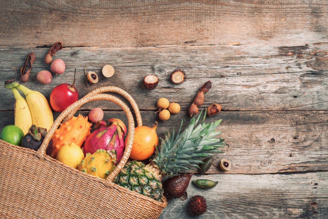 Inicio 7 tropical fruits in a basket on wooden background top view copy space tropical fruits flat lay
